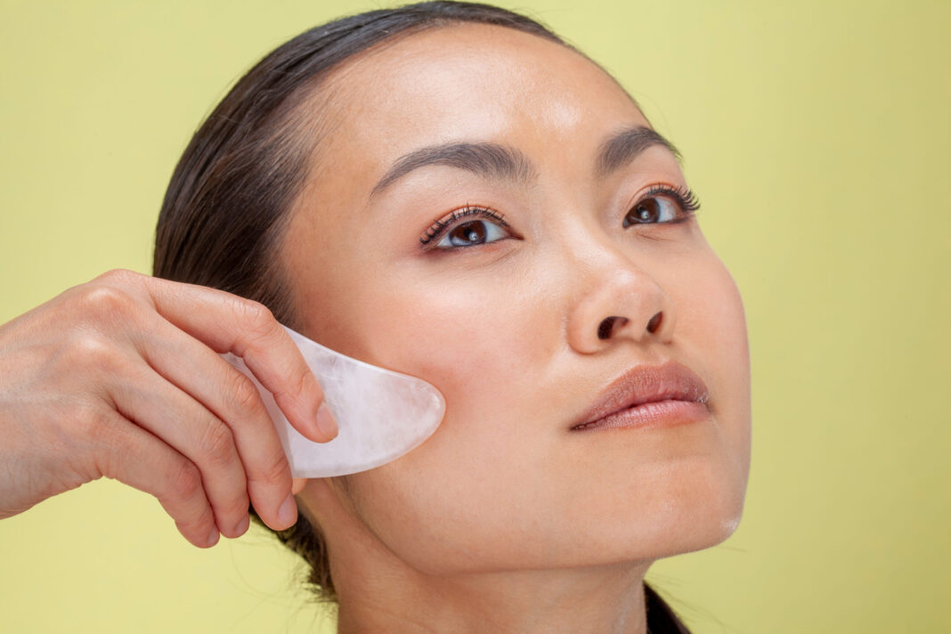Close up of woman treating face with guasha massage
